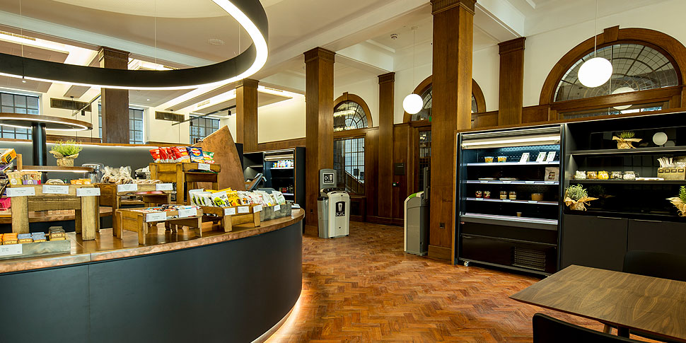 Interior of a busy city food hall with pendant lighting over seating